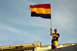 Un chico subido a la bóveda acristalada de Sol (Madrid)ondea la bandera republicana